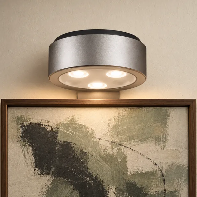 A silver Viso light washing a canvas with warm light